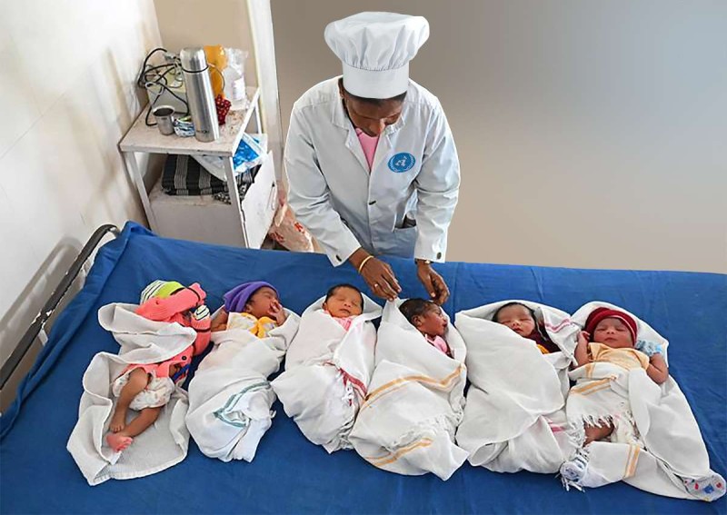 A FRESH BATCH OF NEWBORNS arrives in the kitchen at the U.N. Commissary in New York City, where a chef inspects them before cooking a feast to mark World Population Day 2030.